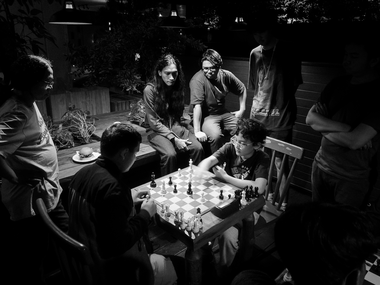 Naro playing chess surrounded by the Chessnuts community
