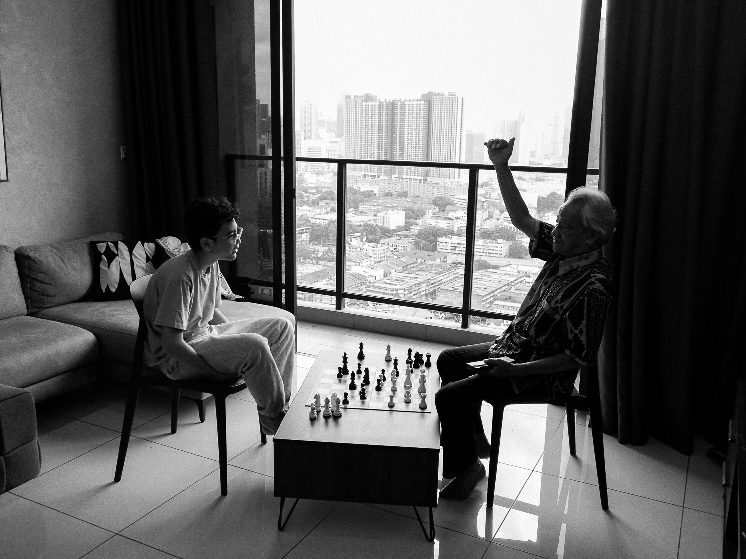 Naro playing chess with his grandfather in Malaysia